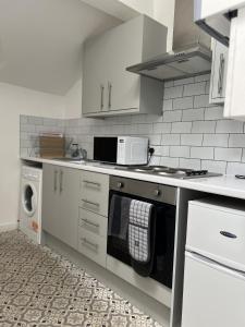 a kitchen with a stove and a microwave at The Hive 2-Bed Apartment with Kitchen and Private Bathroom in Lively Monton Village - Sleeps 4 - Free WiFi - Parking Nearby in Manchester