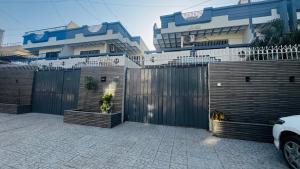 a fence in front of a house with a driveway at Seaview lodge Executive in Karachi