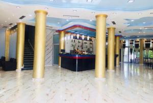 hol hotelowy z kolumnami i barem w obiekcie Fari Hotel w mieście Golem