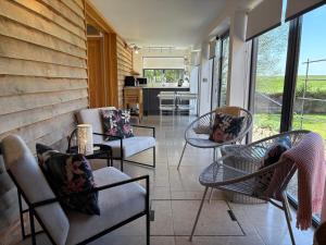 a porch with chairs and tables and a kitchen at Hedges House in Buckingham