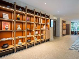 a room with shelves filled with vases and books at Hôtel Mercure Paris Boulogne Pont de Saint Cloud in Boulogne-Billancourt
