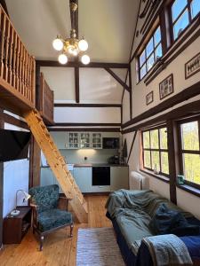 a living room with a staircase in a house at Chalupa Pod Skalou Relax in Paseky nad Jizerou