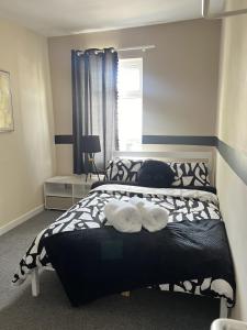 a bedroom with a bed with two towels on it at The Hive 2-Bed Apartment with Kitchen and Private Bathroom in Lively Monton Village - Sleeps 4 - Free WiFi - Parking Nearby in Manchester