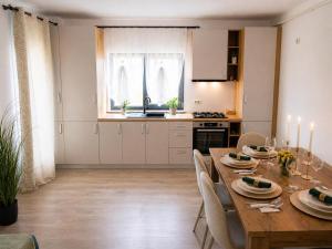 a kitchen and dining room with a wooden table and chairs at Apartament Nou & Modern în Rădăuți 2 Camere Parcare WiFi in Rădăuţi