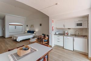 a kitchen and living room with a bed in a room at Apartamentos Borda D´Agua in Albufeira