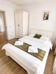 a large white bed with two towels on it at Apartament Nou & Modern în Rădăuți 2 Camere Parcare WiFi in Rădăuţi