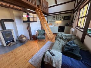 a living room with a bed and a fireplace at Chalupa Pod Skalou Relax in Paseky nad Jizerou