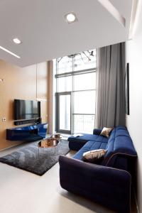 a living room with a blue couch and a tv at Domaniewska Qbik Lofts in Warsaw