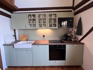 a small kitchen with white cabinets and a sink at Chalupa Pod Skalou Relax in Paseky nad Jizerou +56 photos