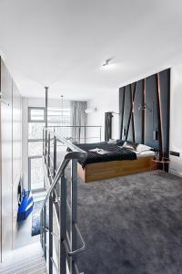 a bedroom with a large bed and a balcony at Domaniewska Qbik Lofts in Warsaw