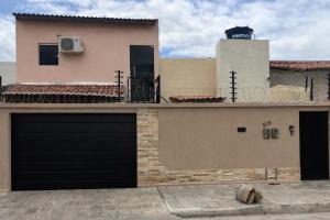 a house with two garage doors in front of it at Rosy Flat 1 Andar in Petrolina