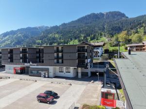 an apartment building with a red car parked in front of it at KitzSki Living in Kitzbühel