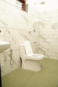 a bathroom with a white toilet and a sink at Twilight Stays Cherai Beach in Pallipuram