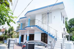 a white house with blue accents at Twilight Stays Cherai Beach in Pallipuram