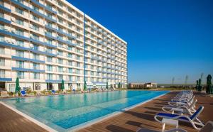 a hotel with a swimming pool with chairs and a building at Cozy Studio Olimp in Olimp