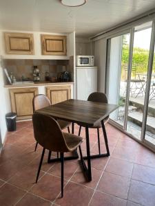 a kitchen with a wooden table and chairs in a room at Les oliviers in Lédignan