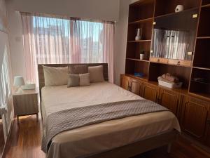 a bedroom with a bed with a large window at City Vibes - Central 3BR Spacious Apartment in Larnaca