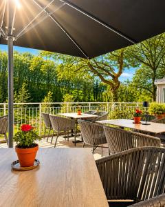 an outdoor patio with tables and chairs and trees at 2tHEIMAT - Hotel & Restaurant in Morbach
