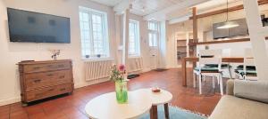 a living room with a couch and a table and a tv at Brasseriehof Historisches Fachwerkhaus in Flensburg 115 m2 Innenhof Parkplatz in Flensburg