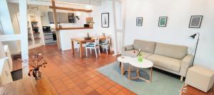 a living room with a couch and a table at Brasseriehof Historisches Fachwerkhaus in Flensburg 115 m2 Innenhof Parkplatz in Flensburg