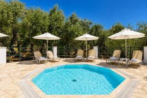 a swimming pool with chairs and umbrellas at Nissaki Sea View Hotel in Corfu