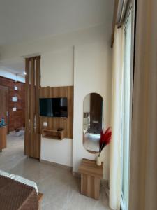 a living room with a mirror and a tv at The Orion Nest in Noida