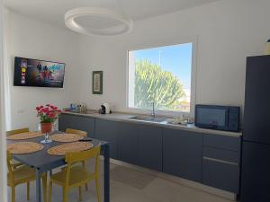a kitchen with a table and a sink and a window at Mondello Felix - appartamenti in villa a 600m dal mare in Mondello