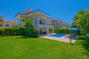 a large house with a swimming pool in a yard at Villa Calıs 2 in Fethiye