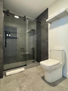 a bathroom with a toilet and a glass shower at The Harbor Inn in Grand Marais