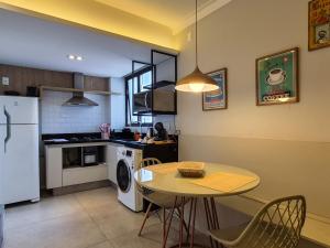a kitchen with a table and a kitchen with a refrigerator at Apartment 13 - Jundiaí in Jundiaí