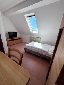 a bedroom with a bed and a tv and a window at W&P Living Zi 5 Bräustüble FeWo 1 2OG l in Buttenwiesen