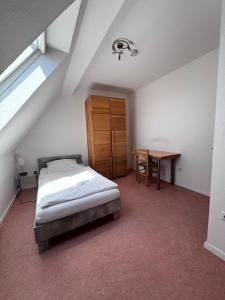 a bedroom with a bed and a desk and a table at W&P Living Zi 5 Bräustüble FeWo 1 2OG l in Buttenwiesen