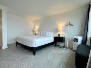 a bedroom with a bed with two lamps on it at The Harbor Inn in Grand Marais
