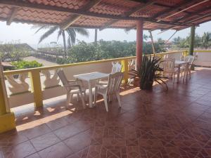 a patio with tables and chairs on a balcony at Centro turístico la playitaa in Chachalacas