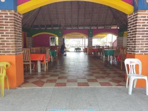 a restaurant with colorful walls and tables and chairs at Centro turístico la playitaa in Chachalacas