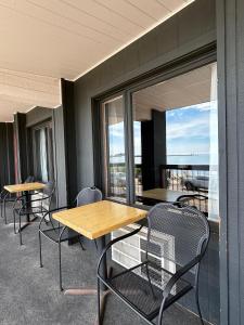 a cafeteria with tables and chairs and a balcony with a view at The Harbor Inn in Grand Marais +11 photos