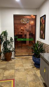 a restaurant entrance with potted plants in front of a door at Pousada Viva Santo Amaro in Santo Amaro +71 photos