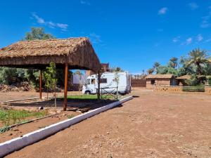 a rv parked next to a thatch hut at Taragalte Park - Motorhomes in Zagora