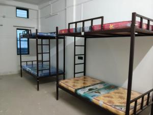a room with three bunk beds and a window at The Palindrome in Guwahati +9 photos