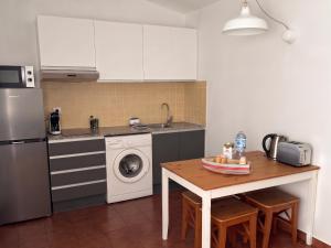 a kitchen with a table and a washer and dryer at Apartamento Binibeca Nou Cami de Cavalls in Binibeca