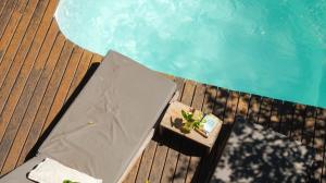 an umbrella sitting on a deck next to a swimming pool at Casa Flor in Ilha de Boipeba