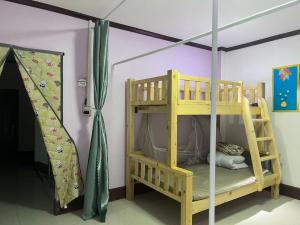a bunk bed with a ladder in a room at FUBON World Guesthouse in Ban Nongpapao