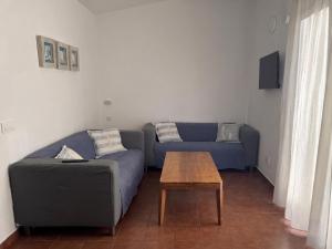 a living room with a blue couch and a table at Apartamento Binibeca Nou Cami de Cavalls in Binibeca