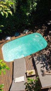 a small swimming pool with two loungers on a wooden deck at Casa Flor in Ilha de Boipeba