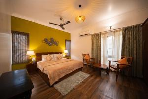 a bedroom with a bed and a table and chairs at Elegant holiday homes Coorg in Somvārpet +101 photos