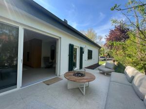 a patio with a table and a couch at Fészek Villa in Balatonszemes