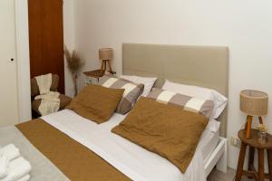 ein Schlafzimmer mit einem Bett mit weißen Laken und braunen Kissen in der Unterkunft DEPARTAMENTO cerca de CABA hasta 4 personas Parking Gratis Patio ideal familias estadias cortas por Trabajo Recitales Salud y Capacitaciones in Martínez