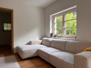 a living room with a white couch and a window at Fészek Villa in Balatonszemes +19 photos