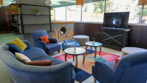 a living room with blue couches and a flat screen tv at ZAG Coliving Punta del este in Punta del Este