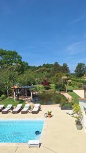 a swimming pool with lounge chairs and a pond at Villa du Rosais in Saint-Hilaire-de-Talmont